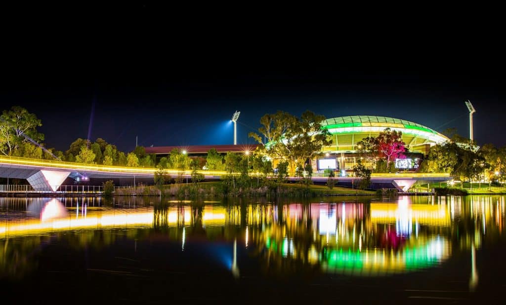 VIP Elite Escort Adelaide 17 a night scene of a building and a bridge over a body of water